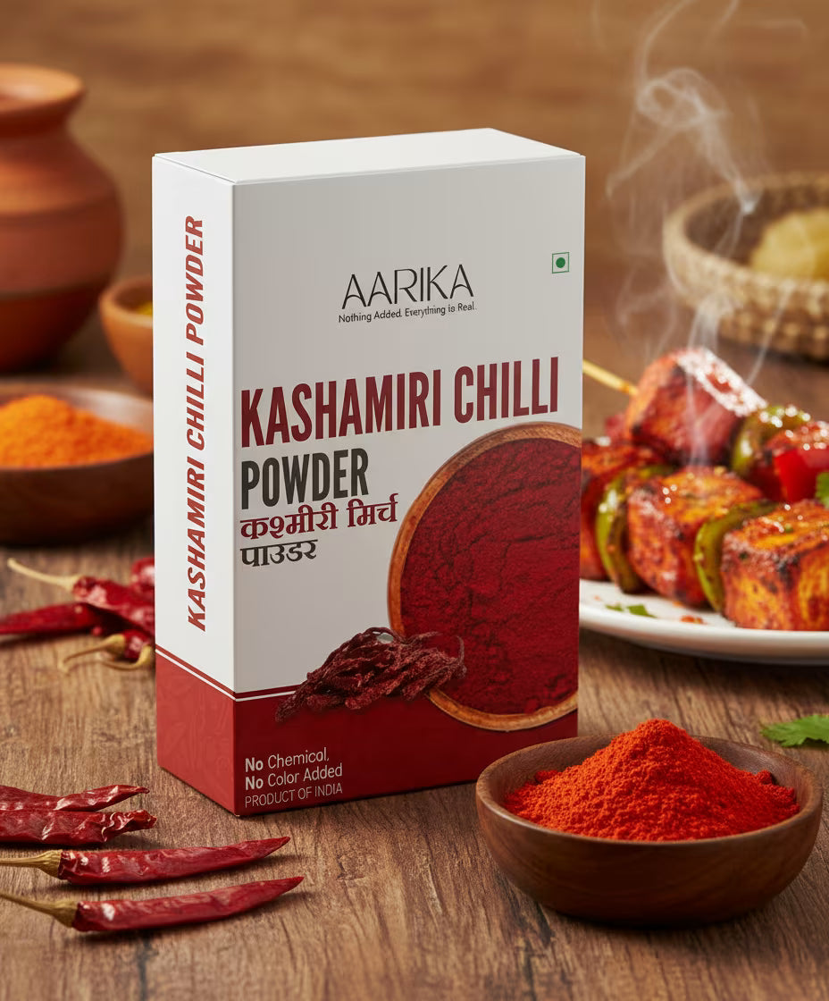 Flavorful kitchen king masala for sabji and curry Best kitchen king masala spice mix for Indian cooking Aarika Kashmiri Chilli Powder packaging with chili peppers and food in the background